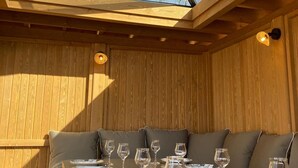 A wooden interior with a table set for dining, a skylight, and a wall-mounted light fixture. - Spacious lodge in Sanchey near the lake, sauna, games, close to nature (Sanchey)
