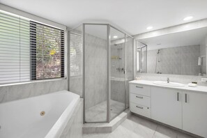 A modern bathroom with a glass-enclosed shower, a bathtub, and a vanity with a mirror. - Beautiful Belmore Retreat Easy Walk to Beach (Noosa)