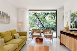 A living room with a sofa, chairs, a coffee table, and a TV stand.