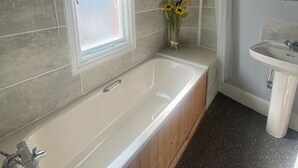 A modern bathroom with a freestanding bathtub, a vanity with a mirror, and a shower area. - Stokesay inn and b and b  (Craven Arms)