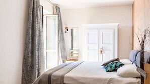 A bedroom with a large bed, a bedside table, a chair, and a wardrobe. - Cosy apartment for 4 guests with WIFI, A/C, TV and terrace (Chiesa)