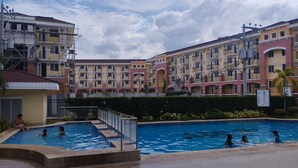 A residential building with multiple balconies and a swimming pool area.