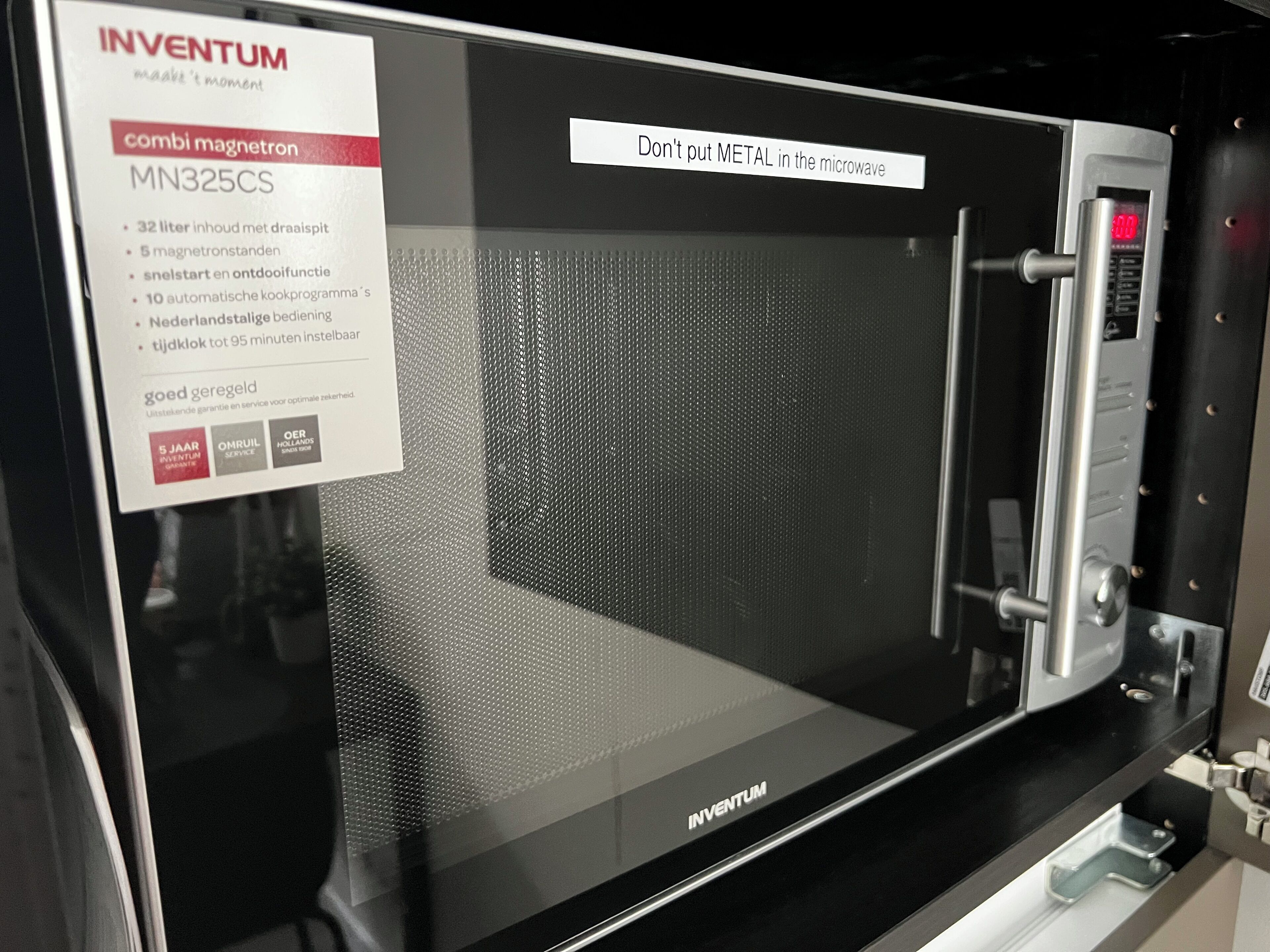 A microwave with a warning label that says "Don't put metal in the microwave."