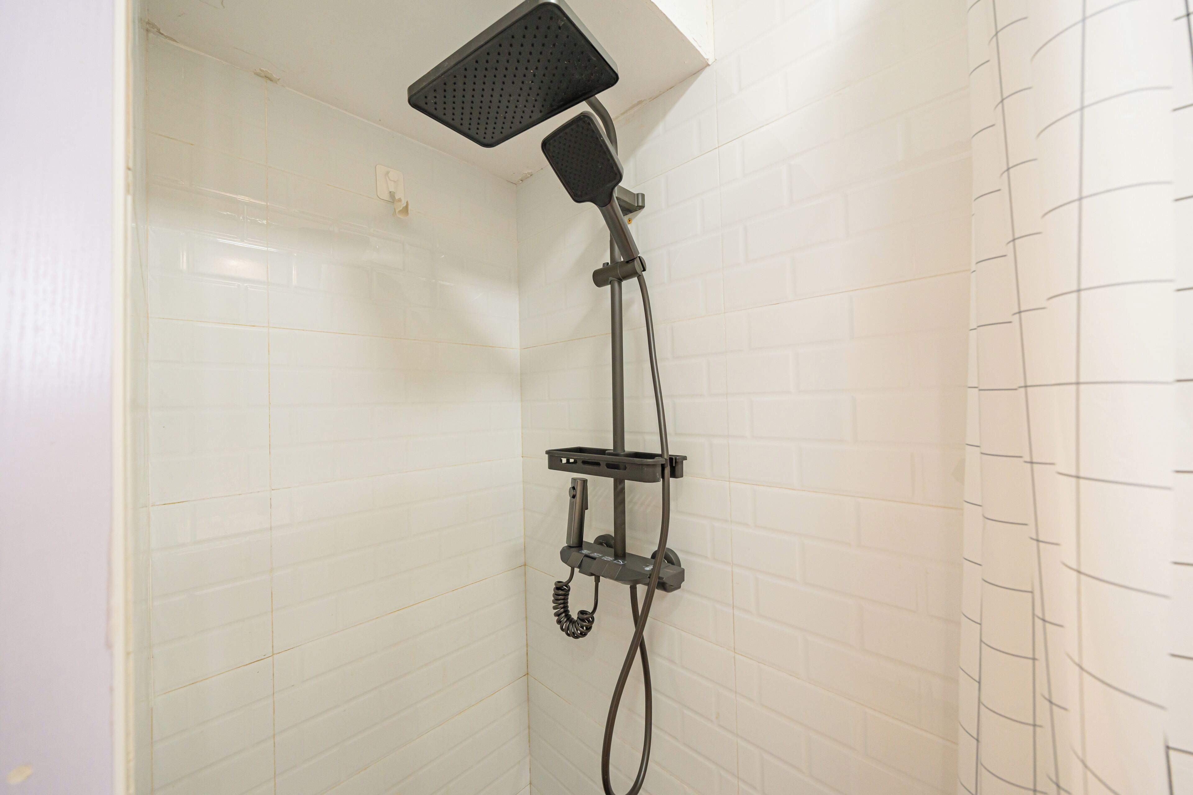Eine Dusche mit Handbrause und fest installierter Duschköpfe an der Wand.