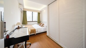 Une chambre d’hôtel avec un lit, un bureau, une fenêtre avec des rideaux et un plafond blanc.