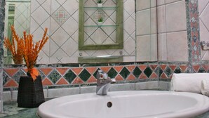Un bagno con lavandino, specchio e piastrelle decorative.