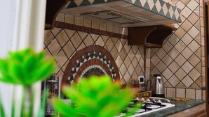 Una cucina con piastrelle a mosaico, un fornello e una macchina per il caffè.