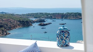 A coastal view with boats, a decorative vase, and a clear sky.