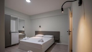 A modern bedroom with a large bed, bedside tables, a wardrobe, and a mirror. - Meraki Rooms (Sarande)