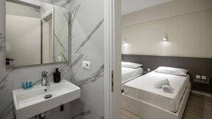 A modern bathroom with a marble sink and a large mirror. - Meraki Rooms (Sarande)