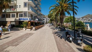 A street with a restaurant named "REPUBLICA" and a building with balconies. - Meraki Rooms (Sarande)