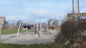 Ein Spielplatz mit Schaukeln und einem Unterstandschild.