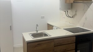 A modern kitchen with a built-in dishwasher, a sink, and wooden cabinetry. - SANTA ANA - SEASONAL RENTAL (Alicante (Alacant))