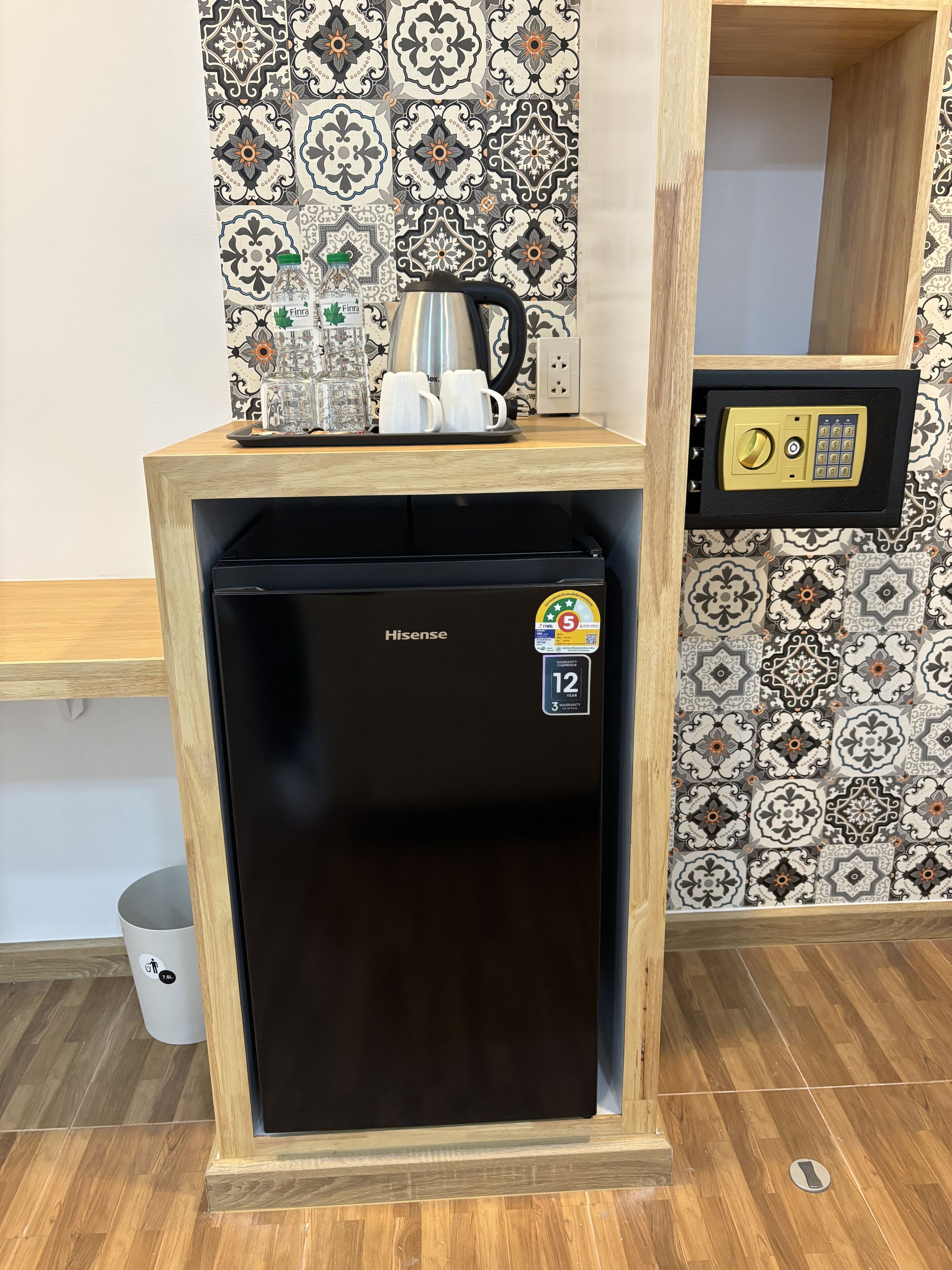 A compact refrigerator with a lock and a keypad, placed on a wooden shelf.