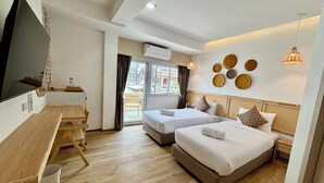 Een hotelkamer met twee bedden, een bureau en een televisie.
