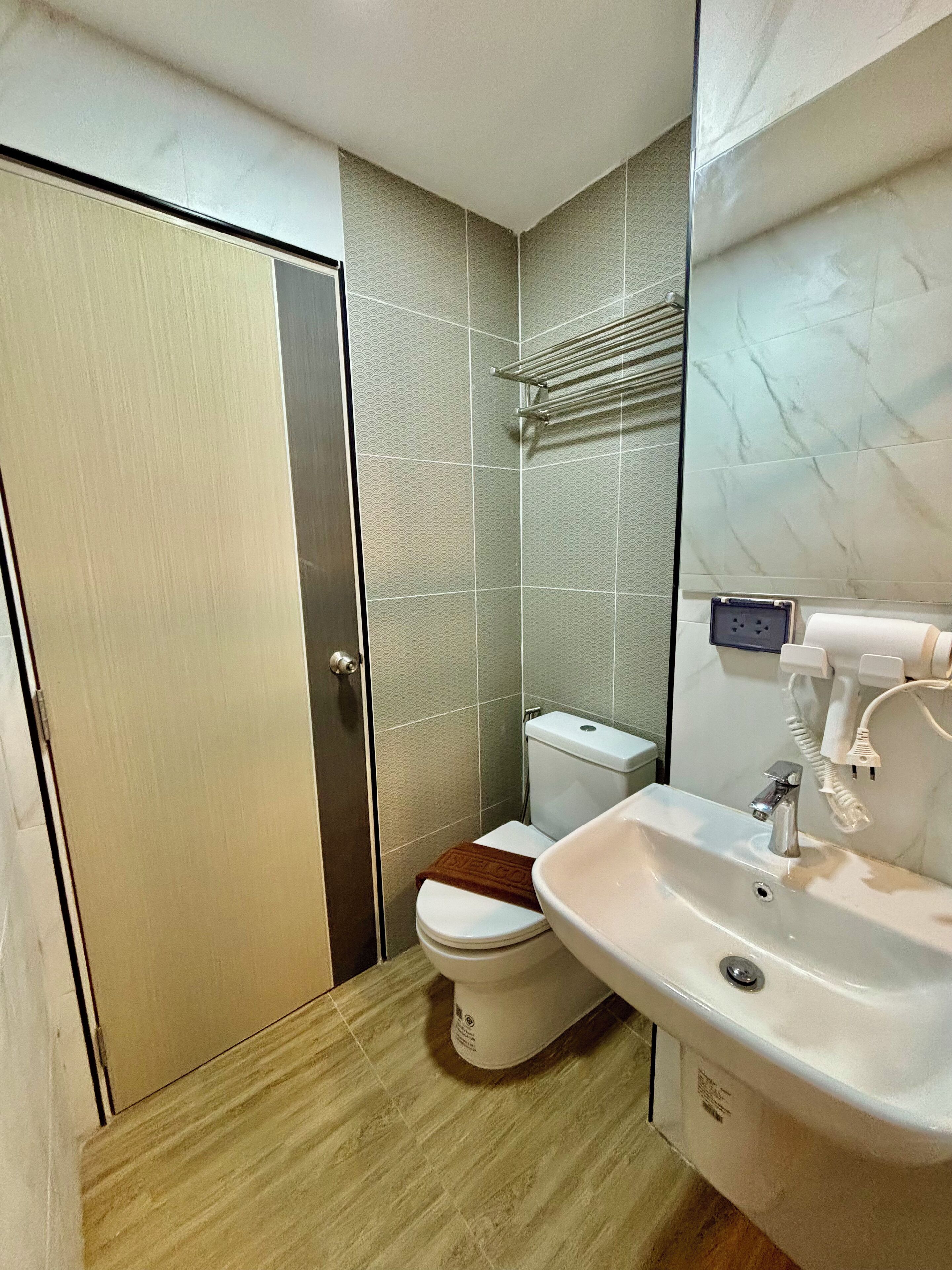 A bathroom with a toilet, sink, and shower area.