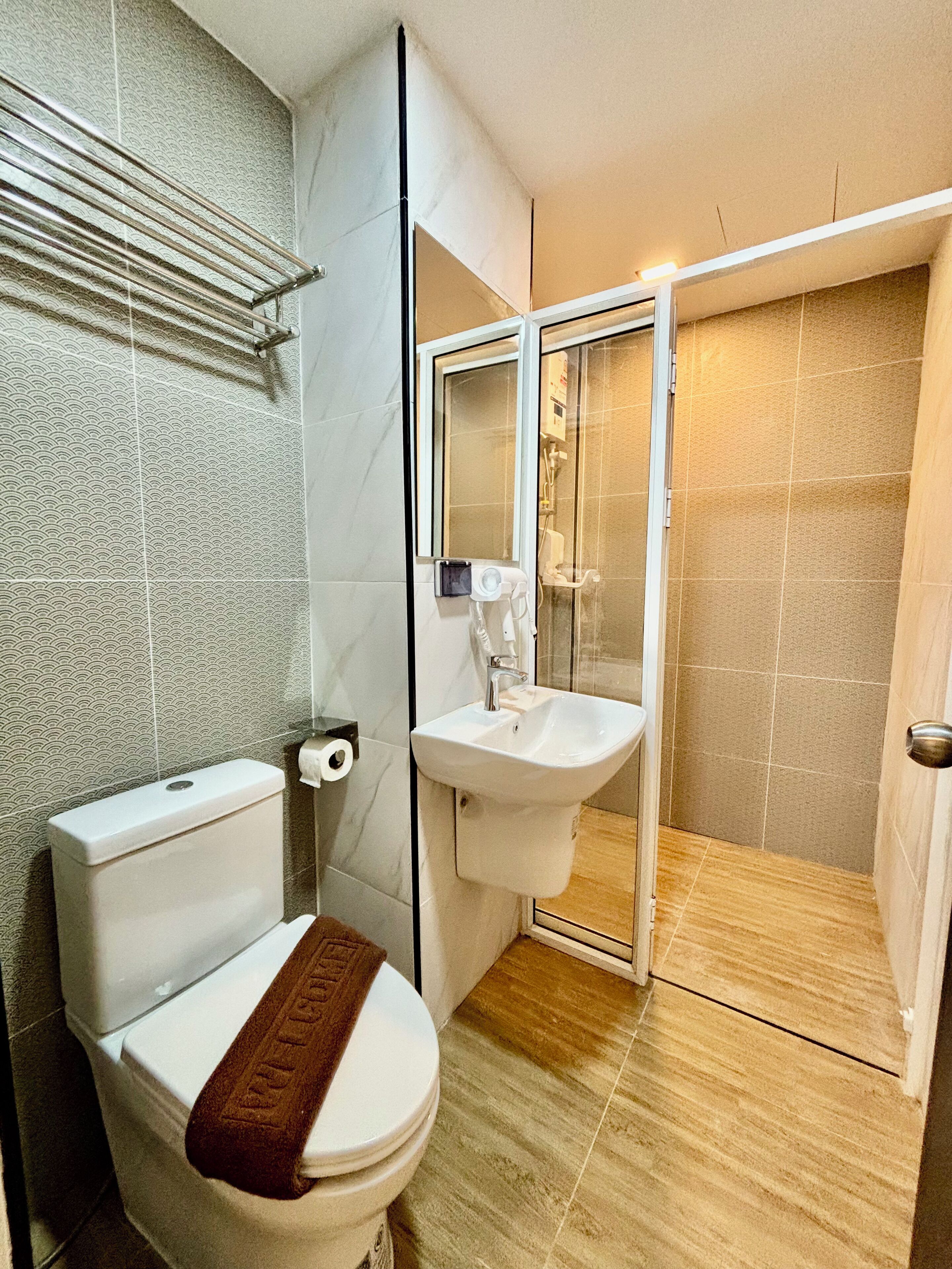 A bathroom with a toilet, sink, and shower area.