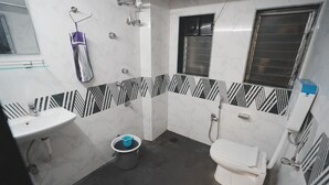 A bathroom with a white sink, toilet, and shower area.