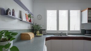 A kitchen with a built-in sink, a wooden bread box, and a potted plant.