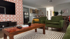 A living room with a television, a coffee table, and a patterned rug.