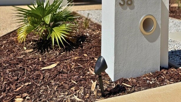 A modern house with a mailbox labeled '38' and a small plant in the driveway.