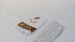 Caja de pañuelos desechables con la etiqueta 'WORLD CARE' sobre una superficie blanca.
