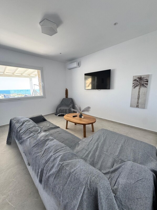 Two-Bedroom Apartment With Sea View & Private Pool | Living area | 44-inch TV with satellite channels - Psaros Village (Mykonos)