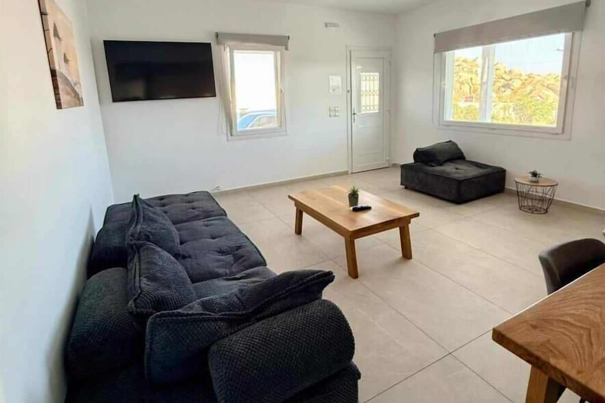Una sala de estar moderna con un sofá, una mesita de centro y una mesa de comedor.