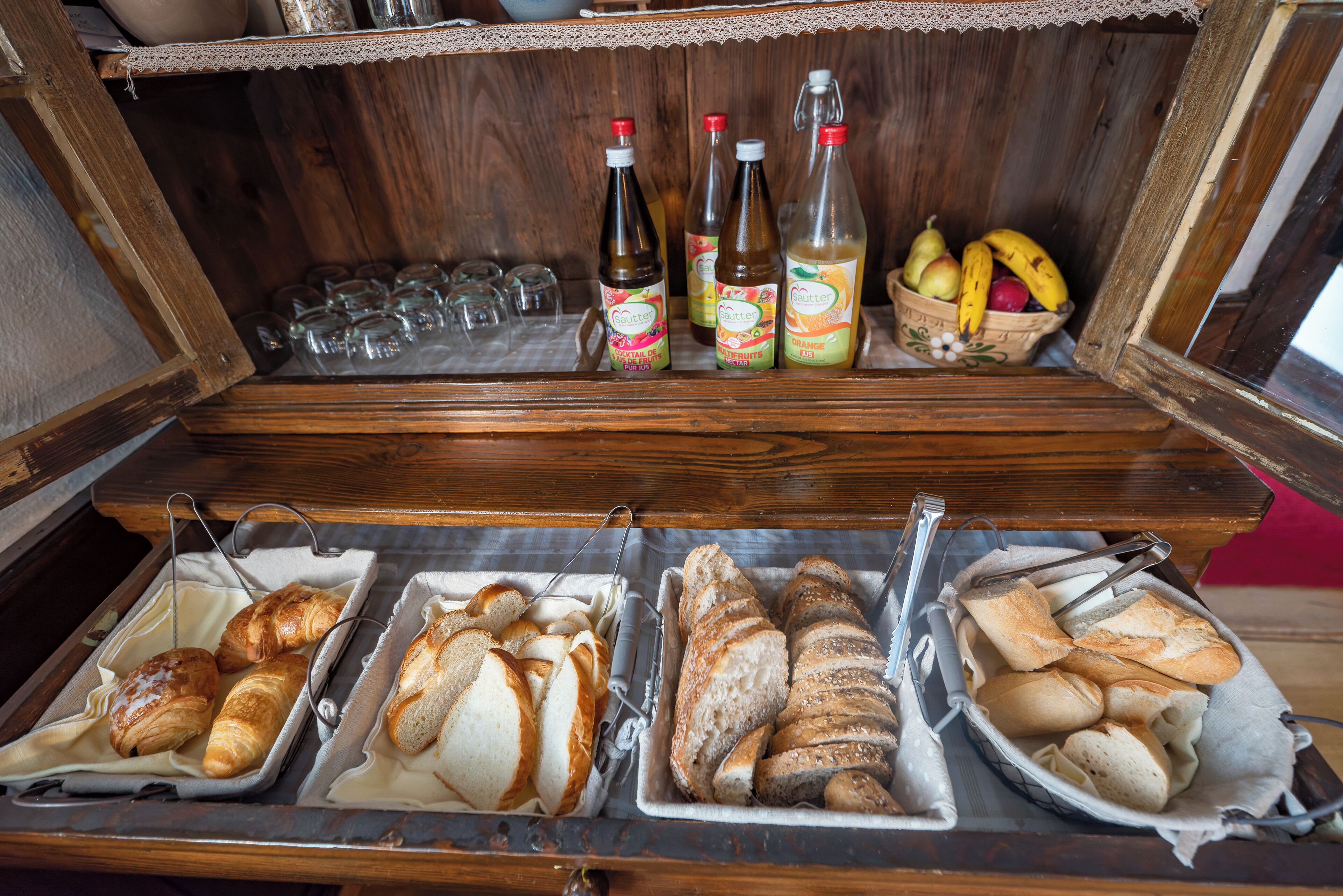 Un buffet de petit-déjeuner proposant un assortiment de pains, de viennoiseries et de boissons.