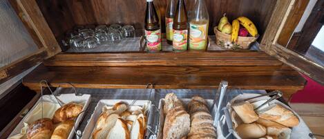 Un buffet de petit-déjeuner proposant un assortiment de pains, de viennoiseries et de boissons.