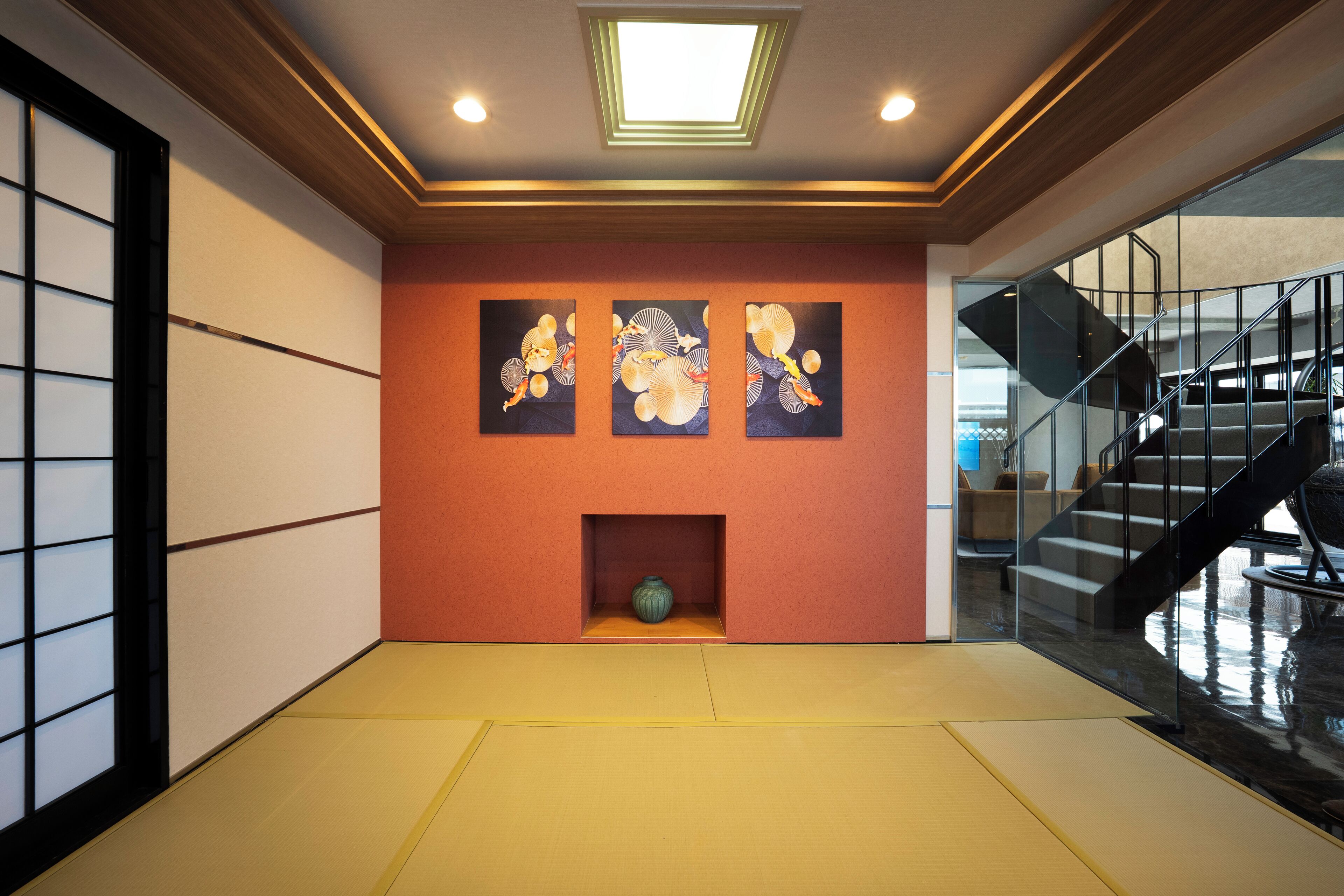 A traditional Japanese interior with tatami flooring, a shoji screen, and a staircase.
