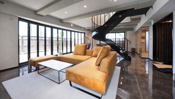 Eine großzügige Lobby mit einem modernen Sofa, einem Couchtisch und einer Treppe.