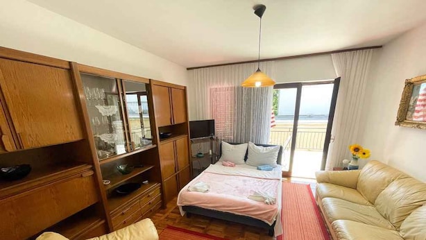 A bedroom with a bed, a sofa, a TV, and a wardrobe. - Apartman Hida (Jadranovo)