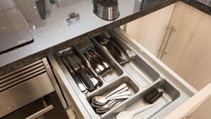 Un cajón de cocina con utensilios y una cuchara.