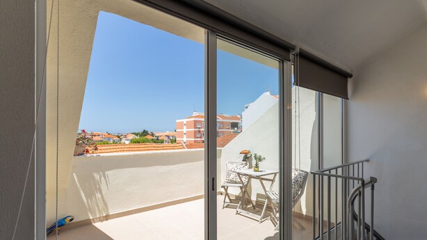 Un balcón con vistas a edificios y una silla.