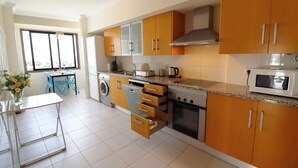Una cocina moderna con armarios de madera, horno empotrado y microondas.
