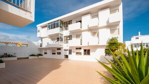 A modern building with multiple balconies and a spacious courtyard.