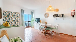 Ein modernes Wohnzimmer mit Essbereich, Fernseher und Küchenzeile.