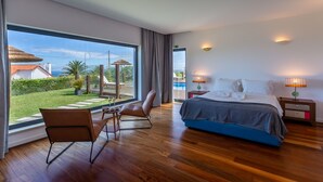 A modern hotel room with a large window, a bed, a chair, and a nightstand.