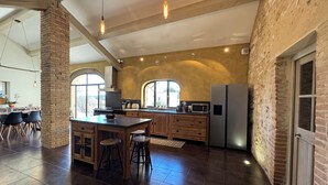 A spacious kitchen with a large island, wooden cabinets, and a stainless steel refrigerator. - Mas provençal, garden, swimming pool and playground for children (Montboucher-sur-Jabron)