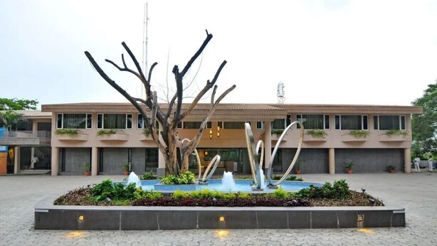 A courtyard with a central sculpture, a fountain, and a building with multiple windows and balconies. - Enrise By Sayaji Bhopal (Bhopal)