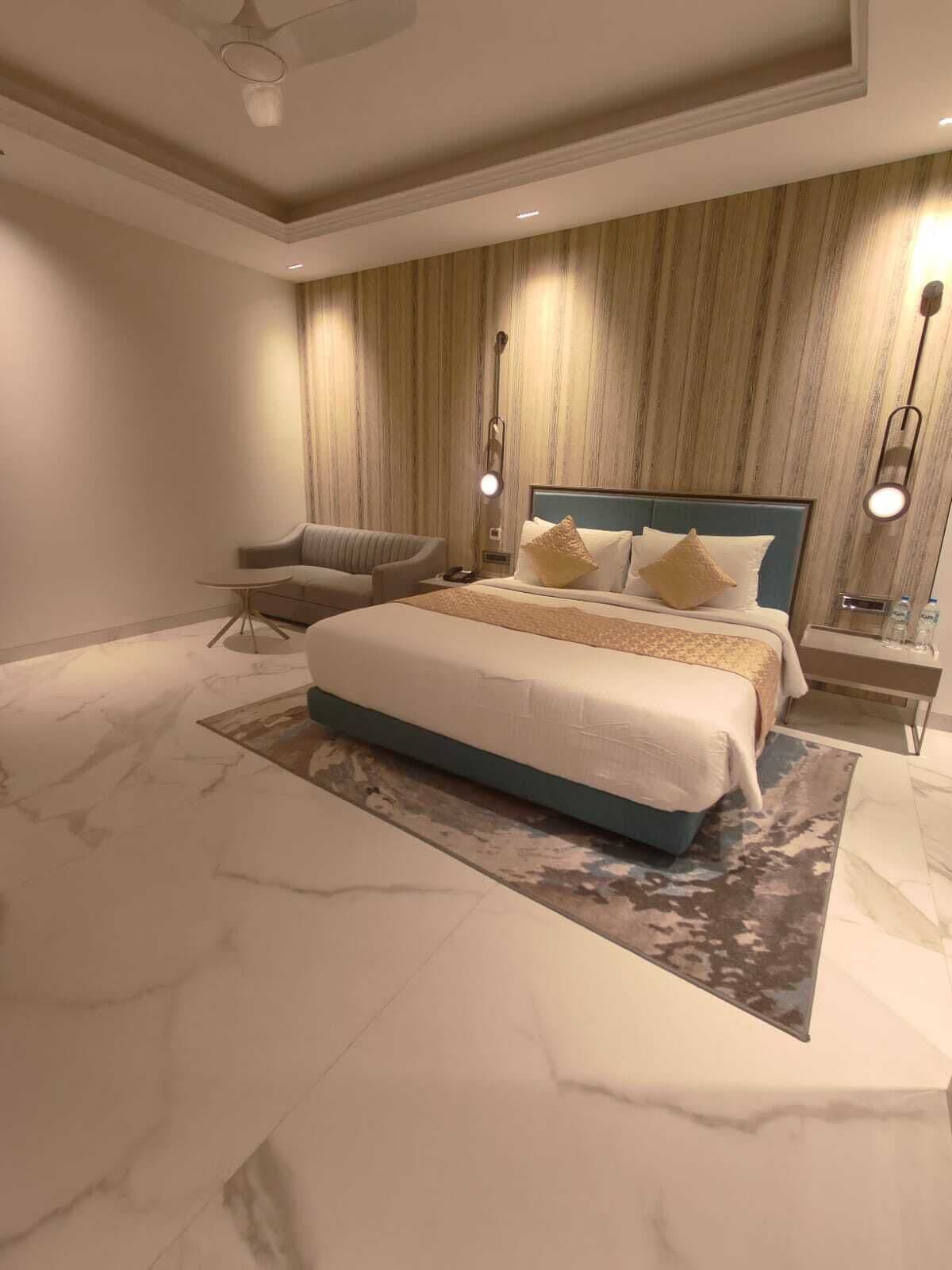 Ein modernes Schlafzimmer mit einem großen Bett, einem Sessel und einem Nachttisch.