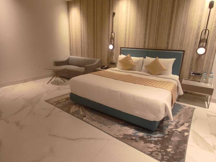 Ein modernes Schlafzimmer mit einem großen Bett, einem Sessel und einem Nachttisch.
