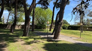 A park with trees, a paved path, and lamp posts. - Villa Riviera 287 - Appartamento Pineta (Pescara)