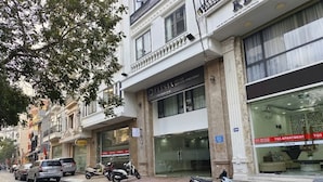 Straßenansicht eines Gebäudes mit mehreren Schaufenstern, darunter eine Beschilderung für 'FLESTA' und 'TQ3 APARTMENT'.