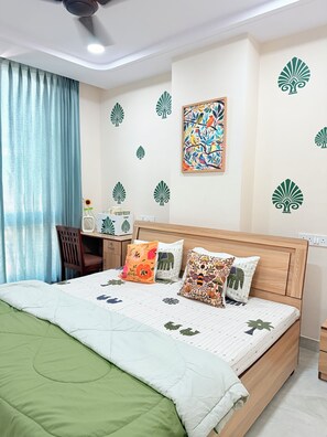 Cozy retreat with a neatly made bed, wooden headboard, and a desk for work or relaxation.