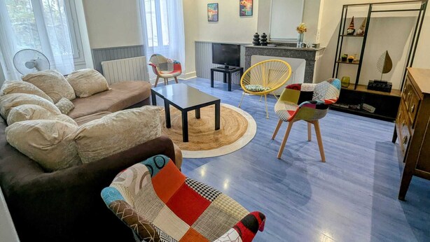 A living room with a sofa, a coffee table, and two chairs. There is a fireplace, a TV, and a mirror on the wall. - Gîte le Foch, rated 3 ***, large gîte in the center of Albi, ideal for groups/families, (Albi)