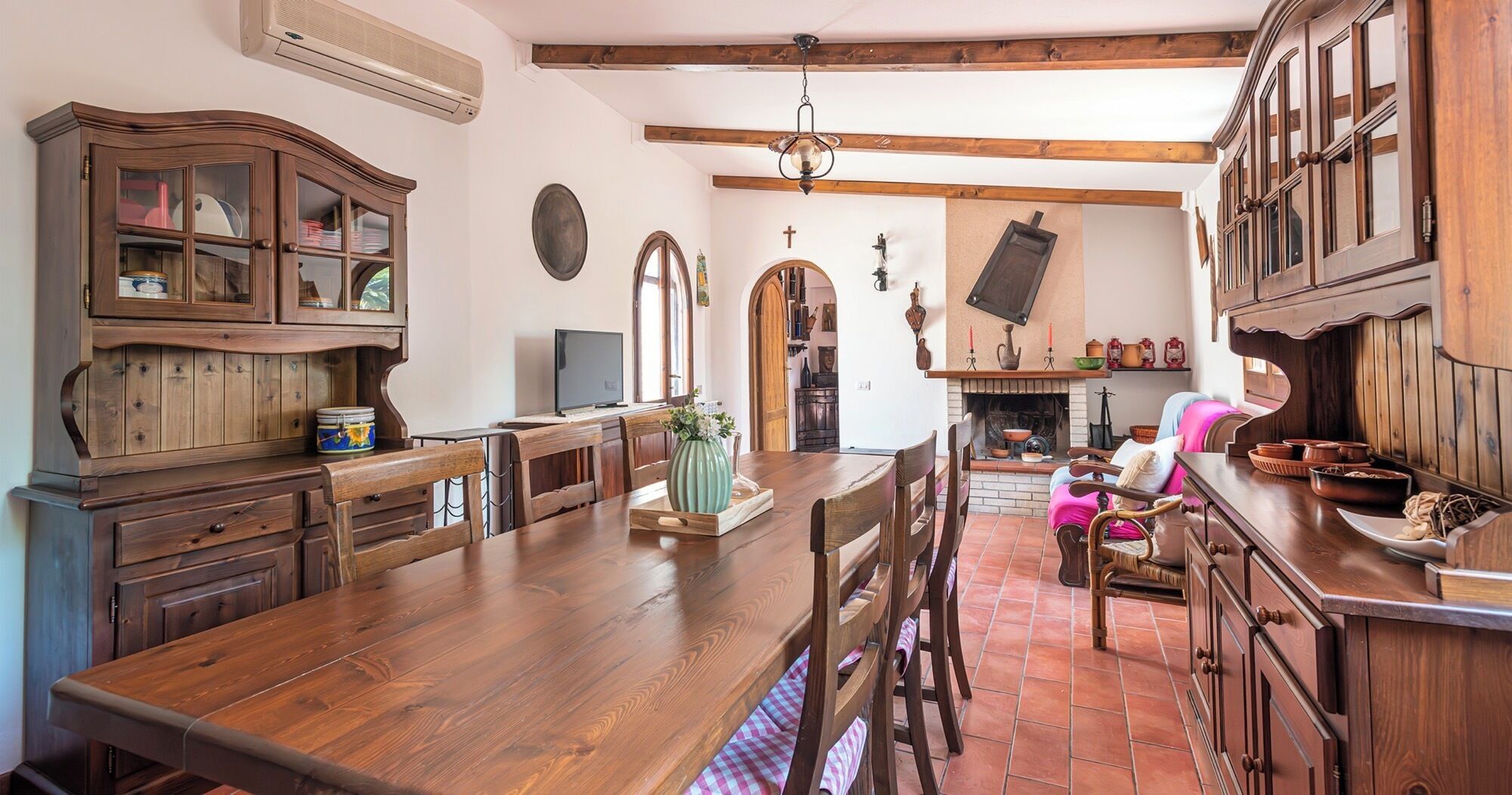 Una cocina tradicional con armarios de madera, una mesa de comedor grande y una chimenea.