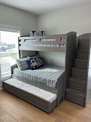 A bunk bed with a desk and drawers, a window with blinds, and a view of a building outside. - Latitude Adjustment -- Relax, Recharge & Play at the Beach (Mexico Beach)