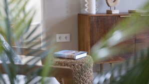 A room with a wooden cabinet, a book on a stool, and a decorative vase with dried plants. - Newly built villa in prime location in Jan Thiel, pool and private parking (Willemstad)